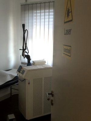 Behandlungsraum mit Lasersystem und Warnhinweis Laser